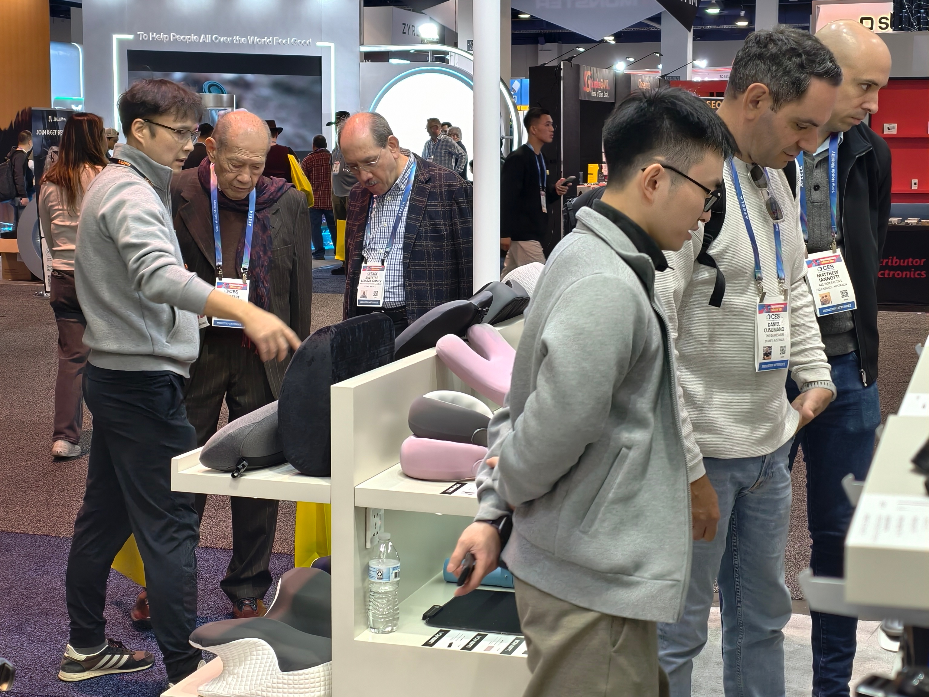 The booth is full of customers making inquiries, and the sales team is answering questions